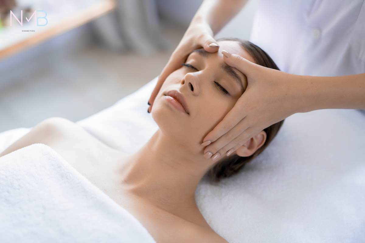 Young woman having anti-stress facial massage in salon at spa resort
